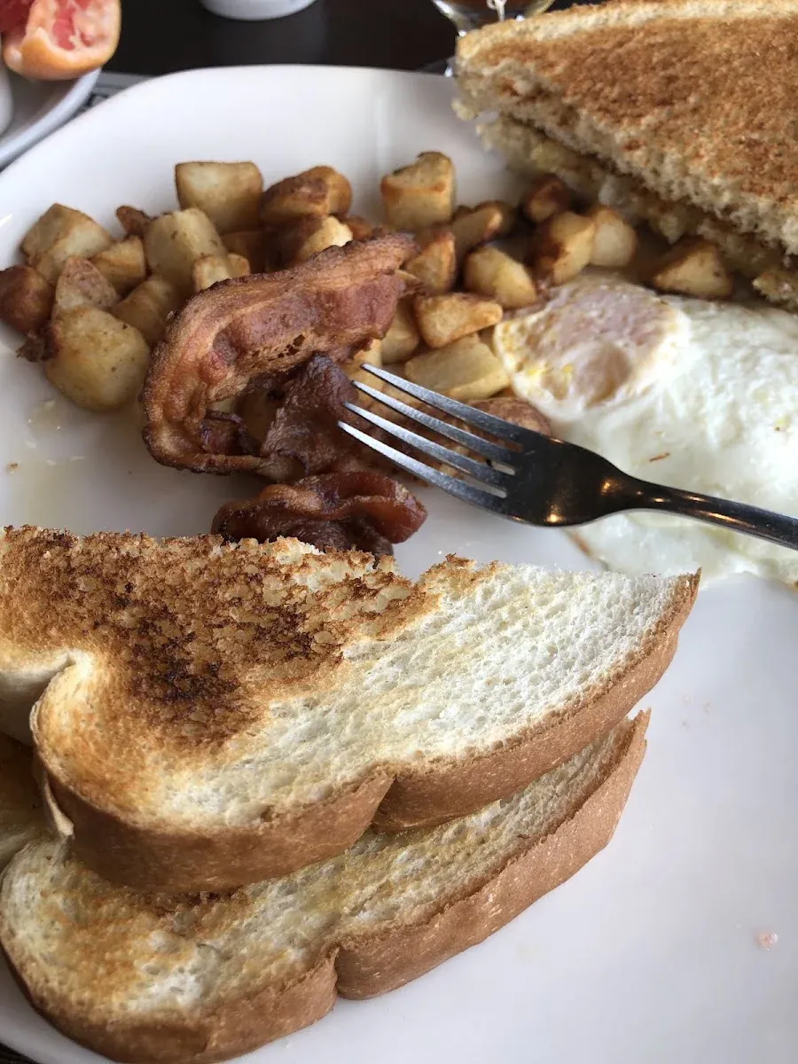 Œufs, bacon, patates rissolées et rôties.