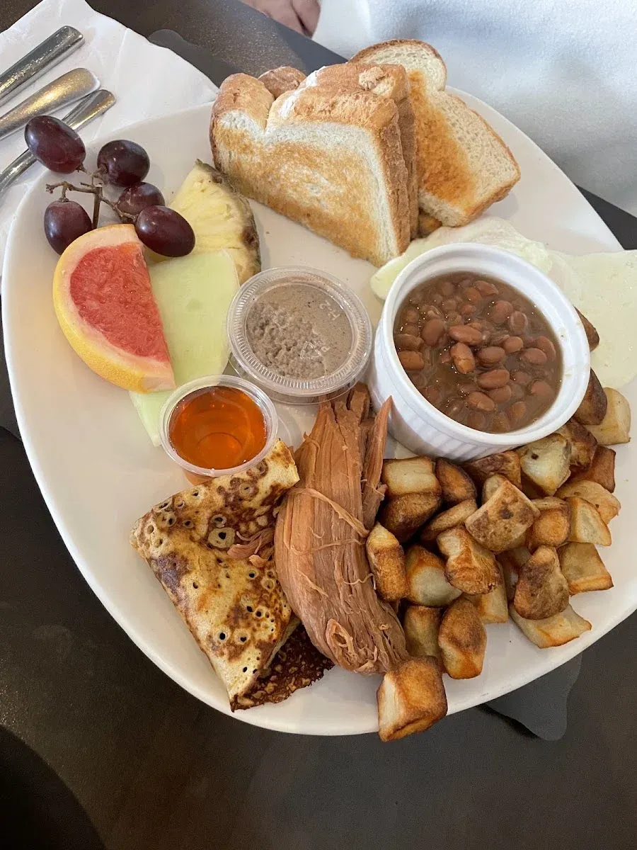 Assiette du matin : fèves au lard, patates, crêpe et fruits.
